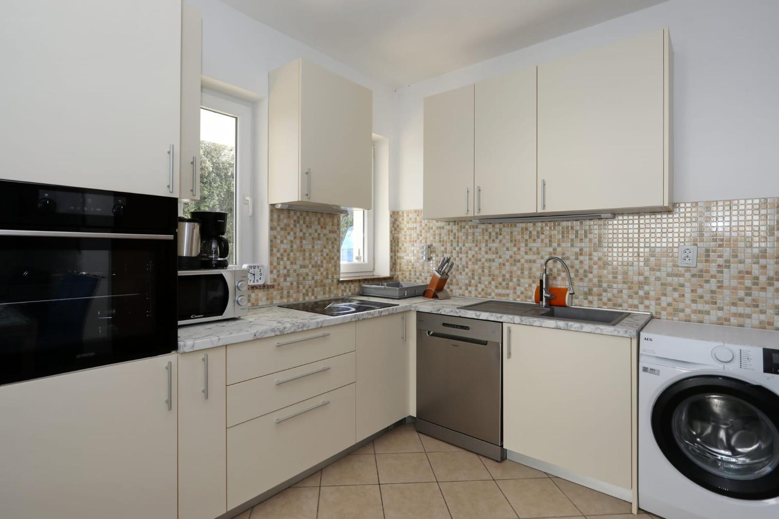 Apartman Mare — kuhinja s pećnicom, indukcijskom pločom, perilicom posuđa i perilicom rublja